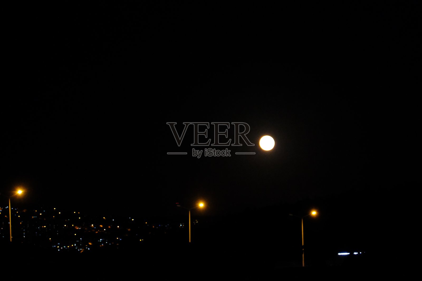 一般的超级月亮，满月与城市的灯光照片摄影图片