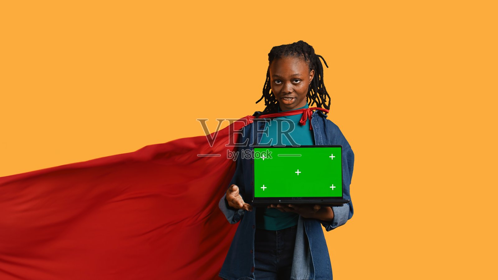 快活的少年扮演超级英雄，展示绿屏笔记本电脑照片摄影图片