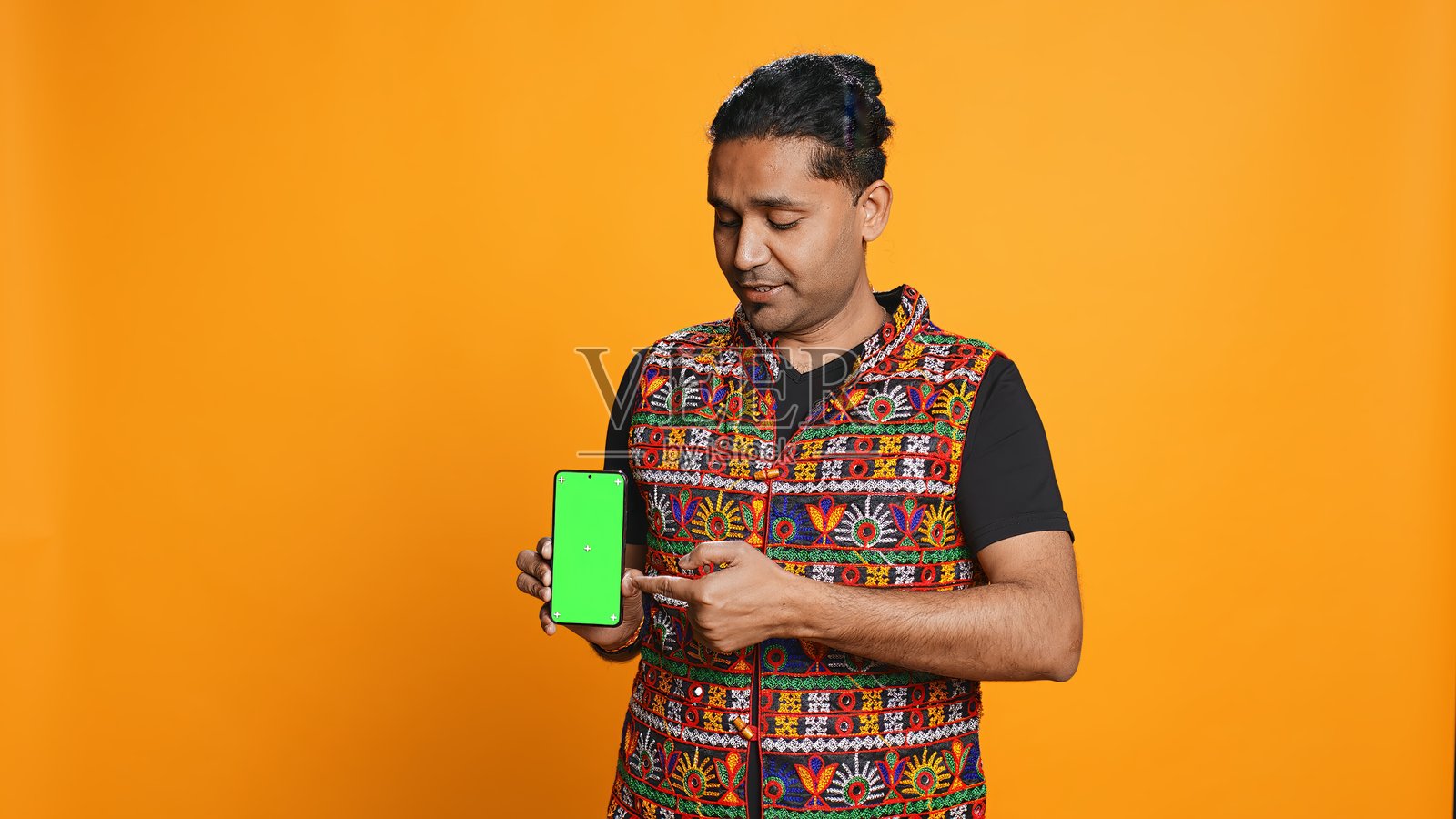 影响者呈现绿屏手机，孤立在工作室背景照片摄影图片