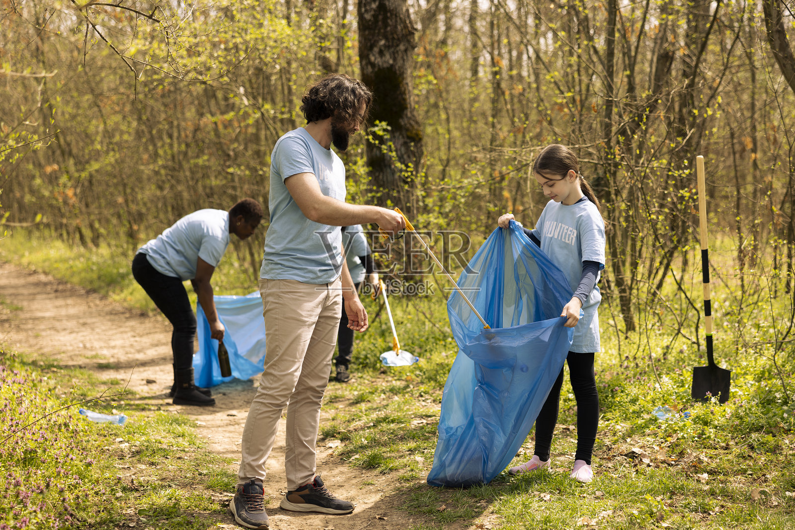 一群积极分子聚集在一起清理森林自然区域照片摄影图片