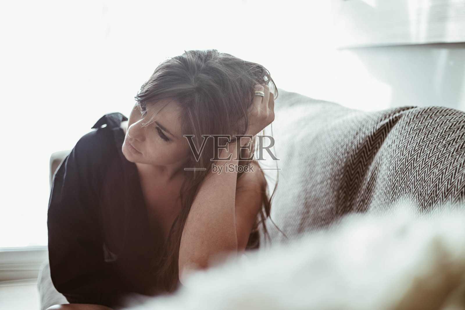 坐在家里的沙发上的紧张女人照片摄影图片