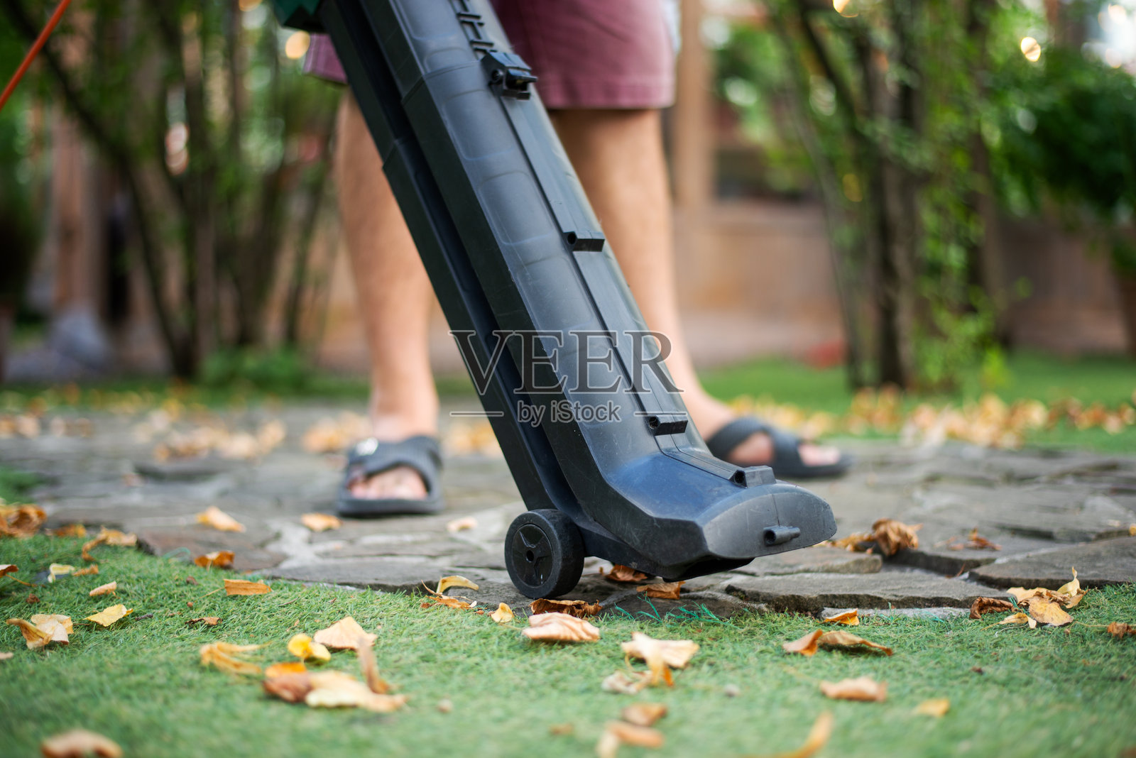 无绳吹叶机。手持，无绳，电动吹叶机在一个花园，选择性聚焦。秋天，秋天的园艺工作在后院、草坪、草地上进行。花园的工作。照片摄影图片