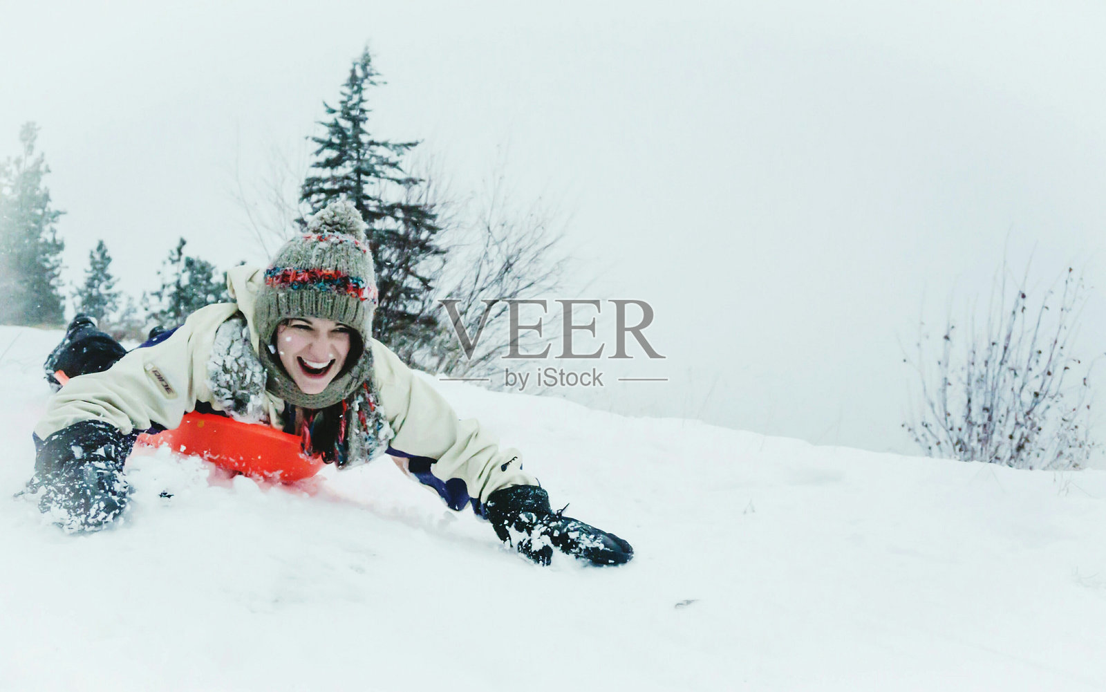 快乐的年轻女子在冬天的雪山上滑雪照片摄影图片