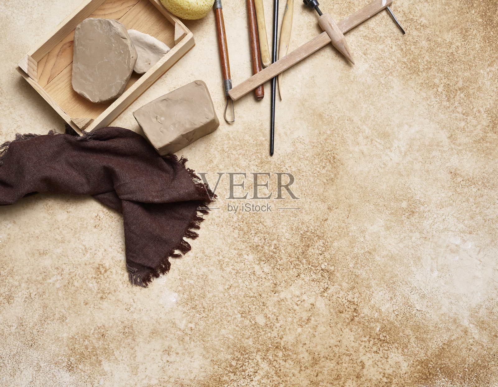 制作陶瓷，妇女的手和工具上装饰的桌子风格的背景，向上看。照片摄影图片