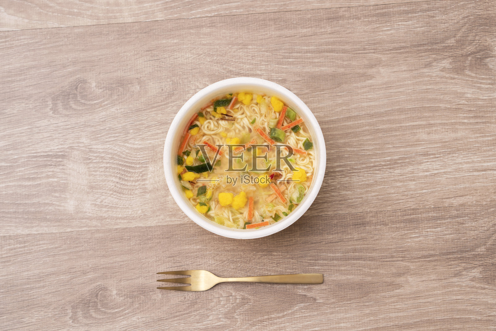 把拉面放在桌子上。杯面搭配多种食材。方便面、冠军面、蔬菜拉面等。照片摄影图片