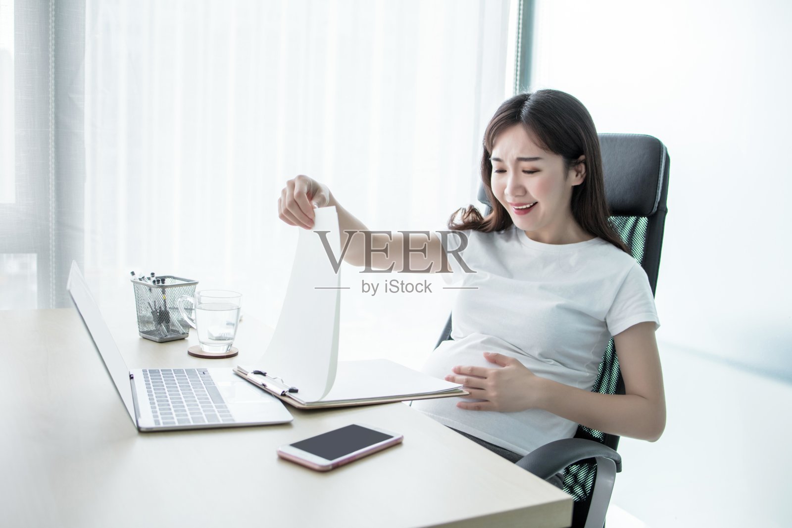 怀孕的女商人在办公室用笔记本电脑工作照片摄影图片