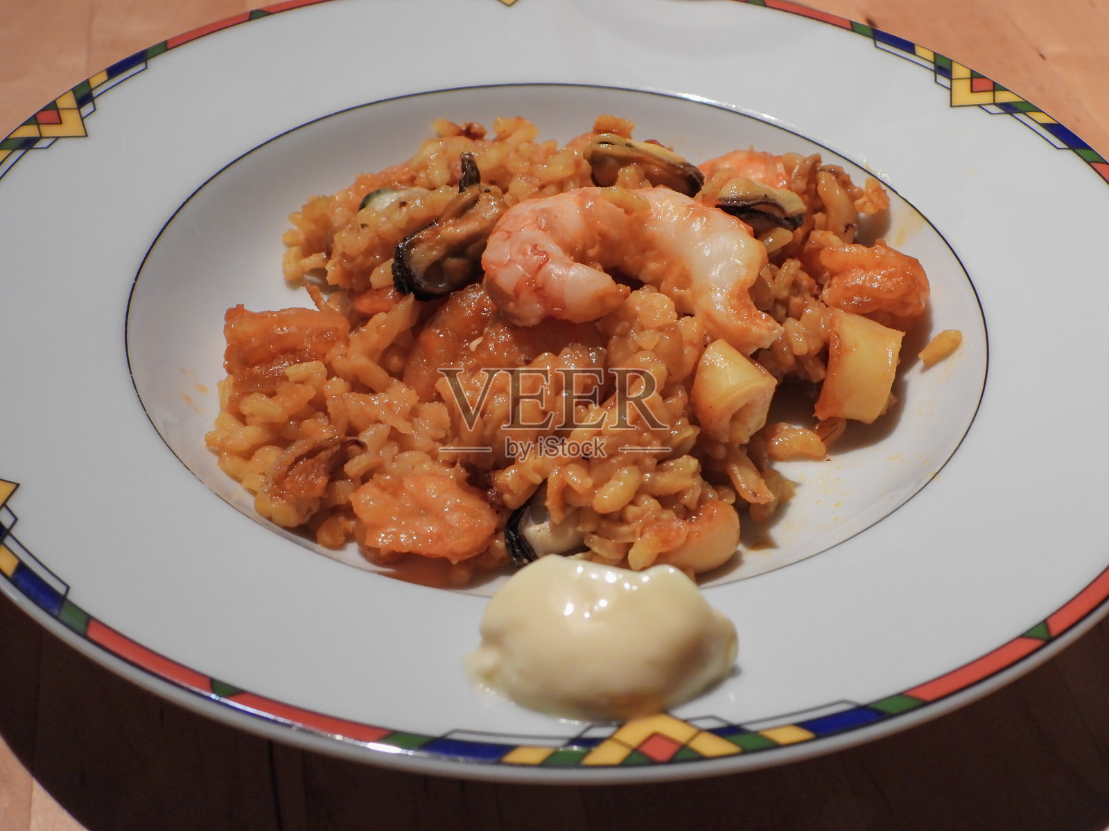 白色盘子上的金色米饭海鲜饭配对虾、虾、墨鱼和贻贝(特写)。照片摄影图片