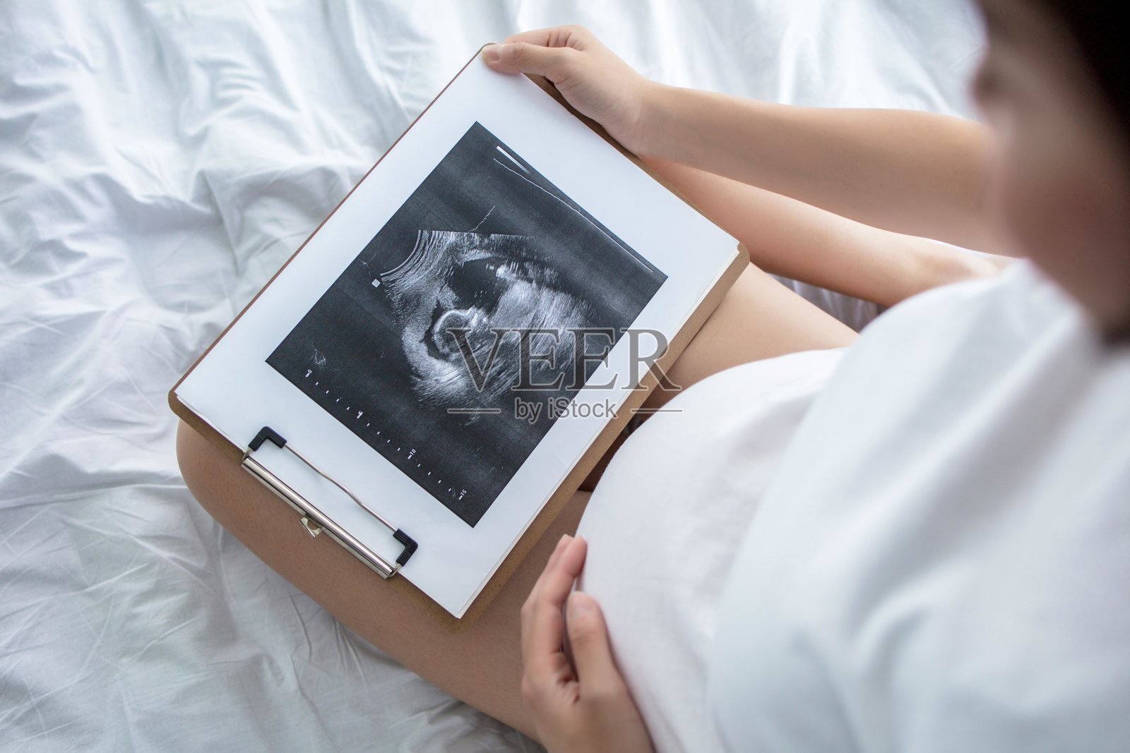 一位孕妇正在看她孩子的超声波图像照片摄影图片