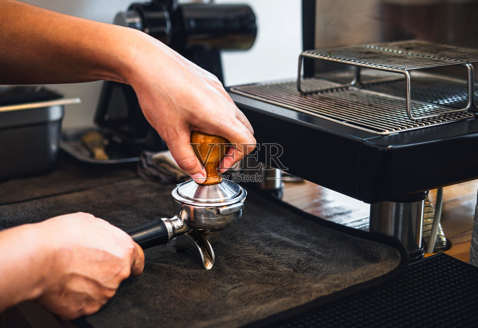 近距离拍摄的手工咖啡师在咖啡店用捣碎机手工压碎咖啡照片摄影图片