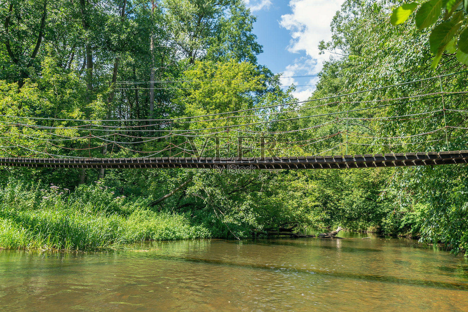 一座横跨小河的木桥照片摄影图片