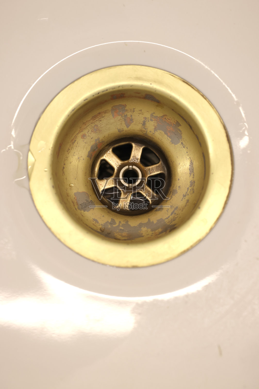 家用陶瓷水槽上镀黄铜的污损塞孔照片摄影图片