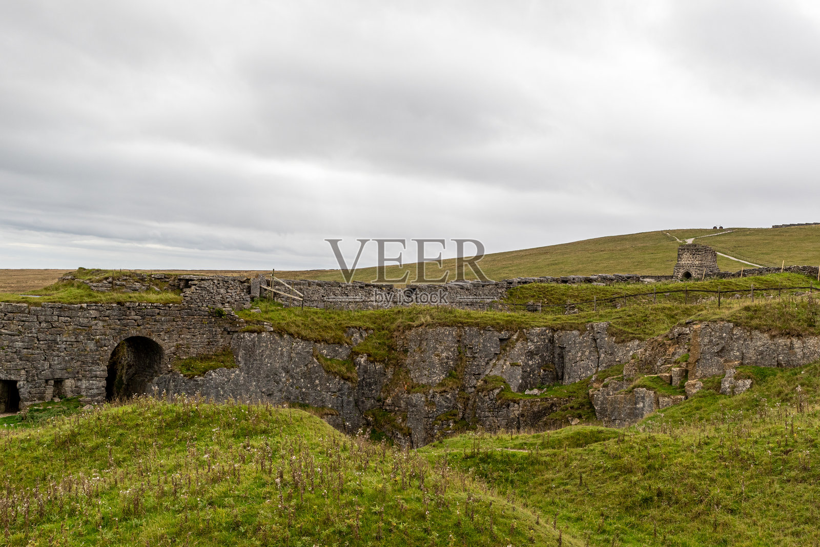 阴天下有石桥和村舍的乡村景观。照片摄影图片