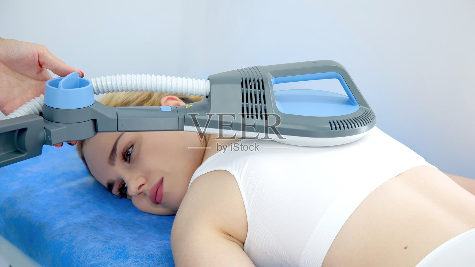 一位年轻女子在现代诊所接受先进的超感应磁疗。非常适合突出尖端的医疗和健康创新。照片摄影图片