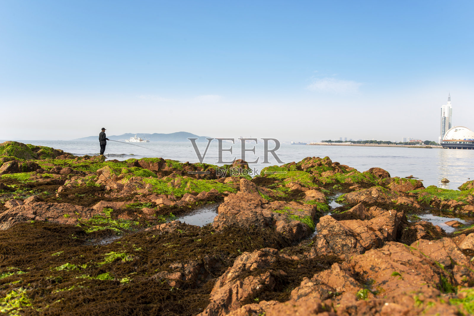 一个男人在海滩上钓鱼照片摄影图片
