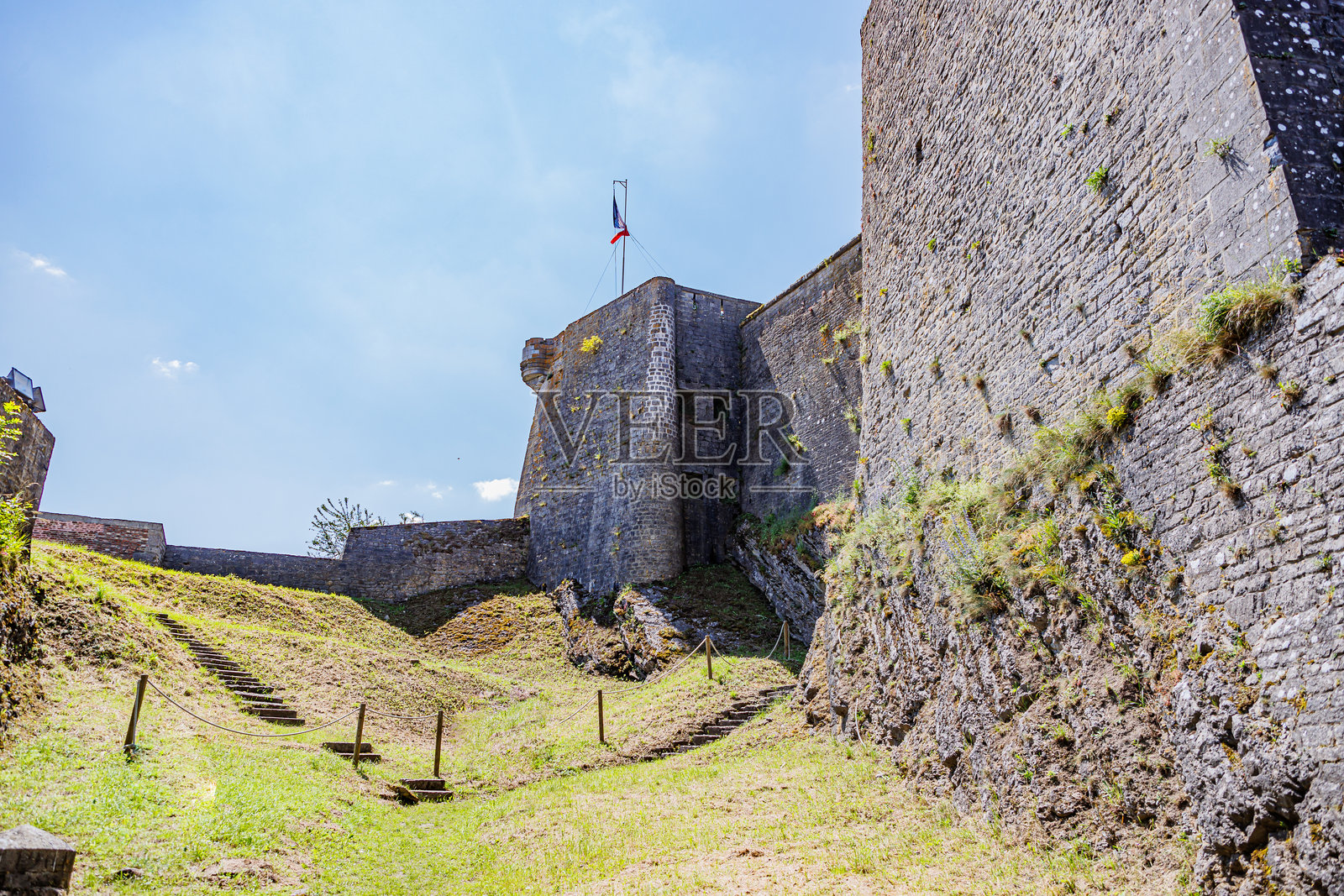 又高又厚的查理蒙要塞石墙，挥舞着法国国旗照片摄影图片