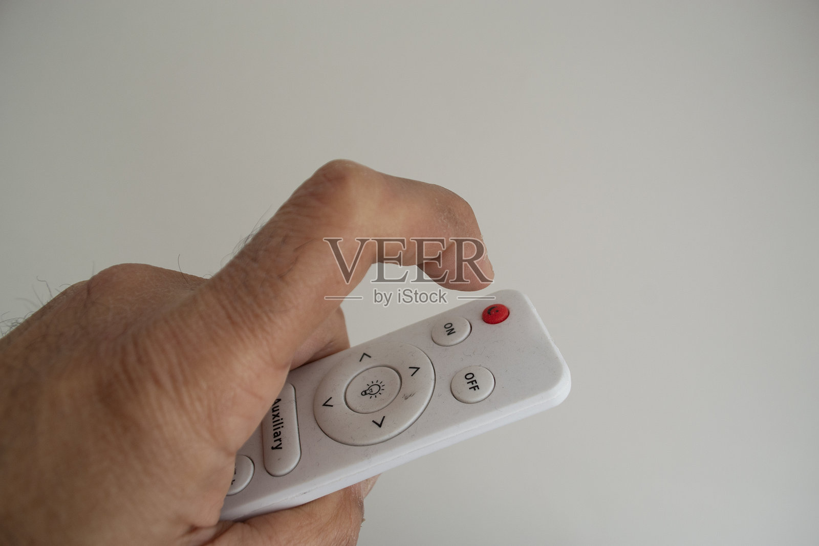 一个男人的手拿着灯的遥控器照片摄影图片