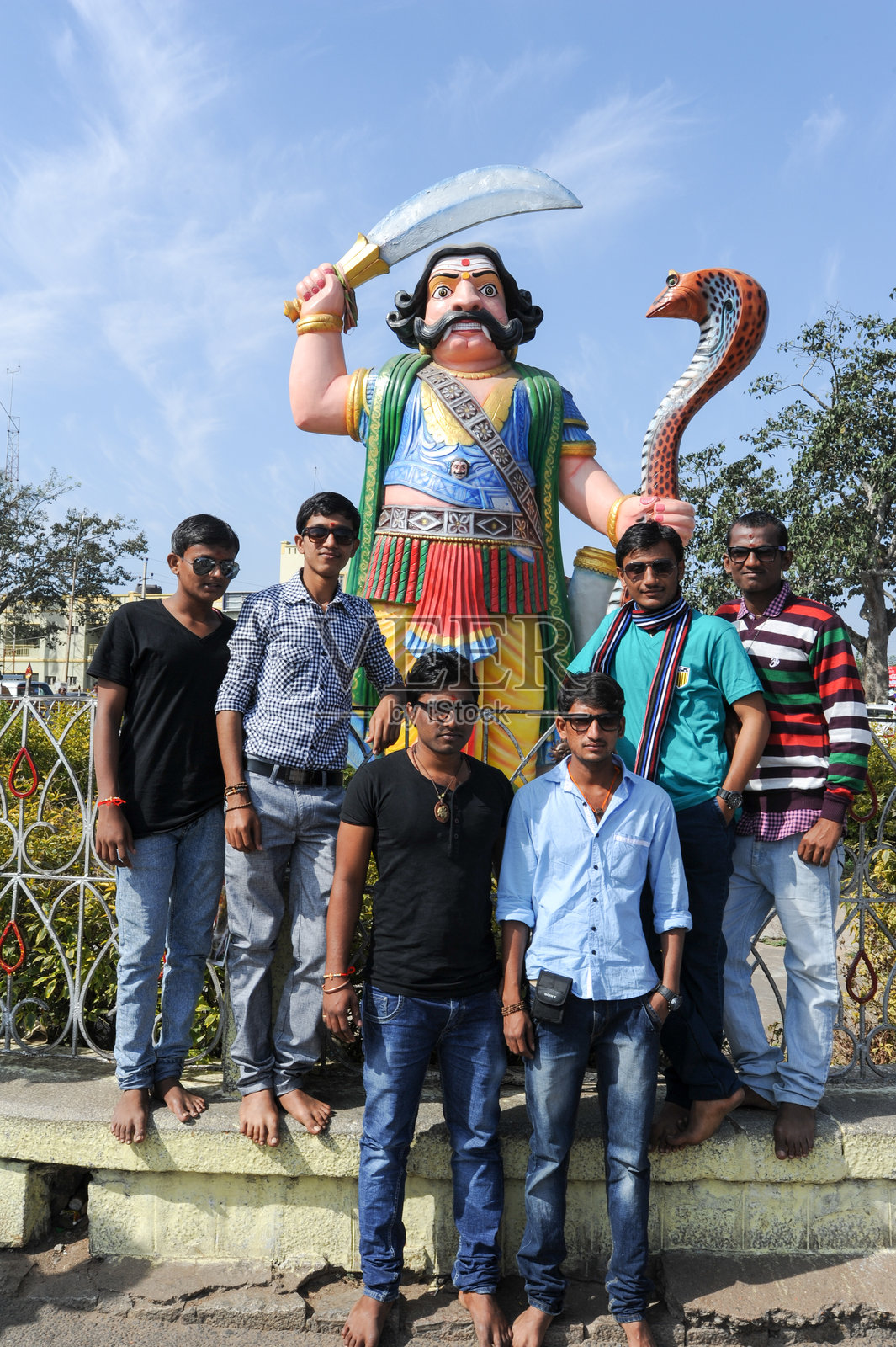 人们在恶魔摩诃沙修罗雕像前摆姿势照片摄影图片