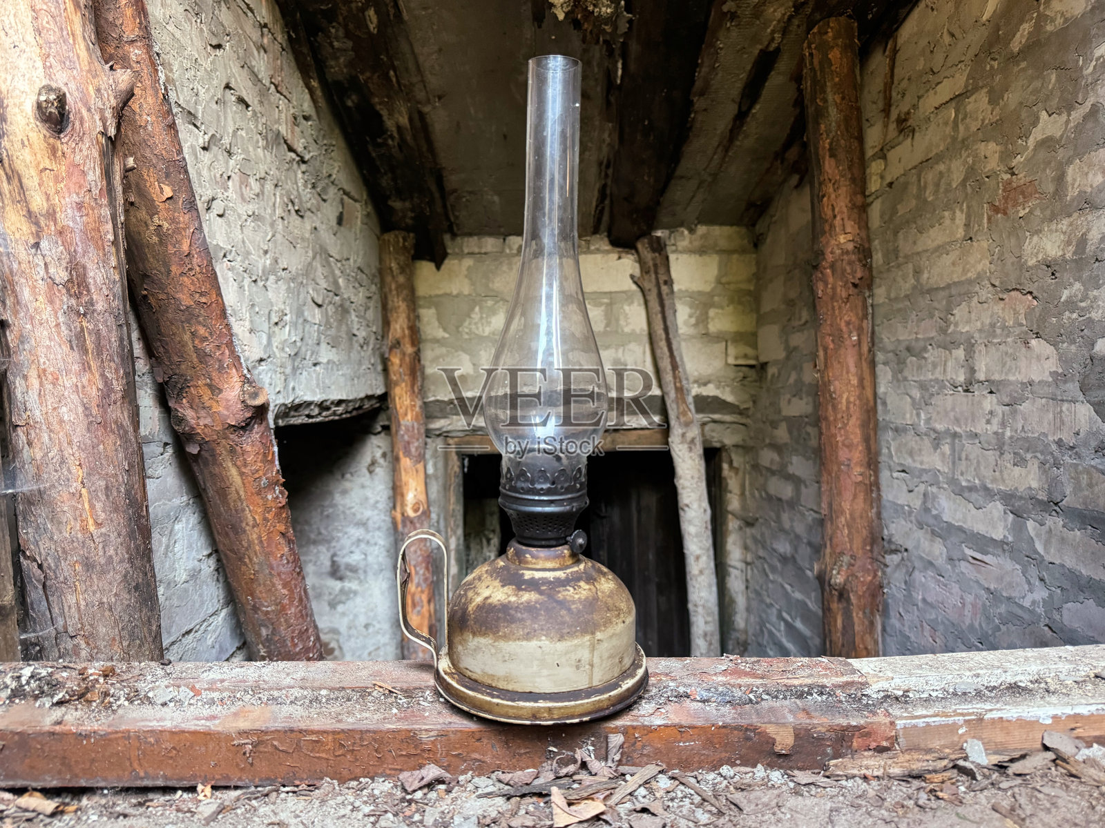 一盏有玻璃灯罩的旧煤油灯。在地窖的台阶上。照片摄影图片