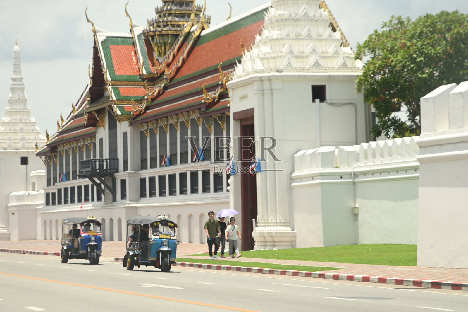 男性驾驶一辆嘟嘟车。让乘客在佛祖附近下车。这种交通工具在曼谷是一种很受欢迎的交通工具。照片摄影图片