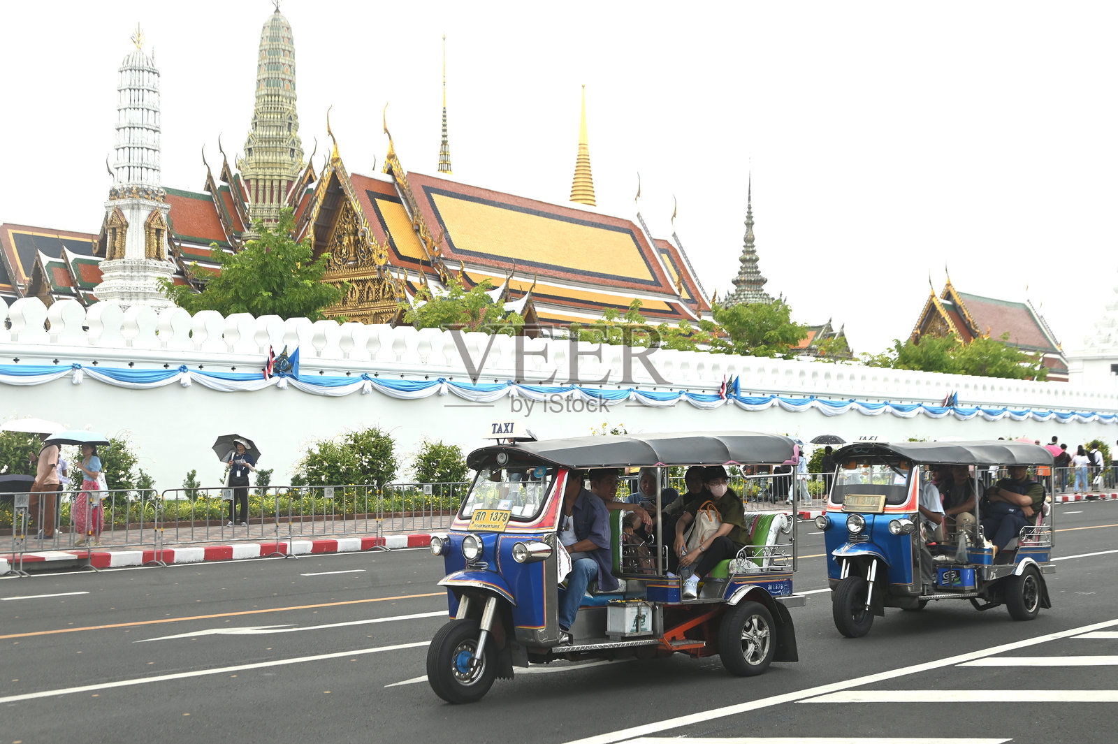 男性驾驶一辆嘟嘟车。让乘客在佛祖附近下车。这种交通工具在曼谷是一种很受欢迎的交通工具。照片摄影图片