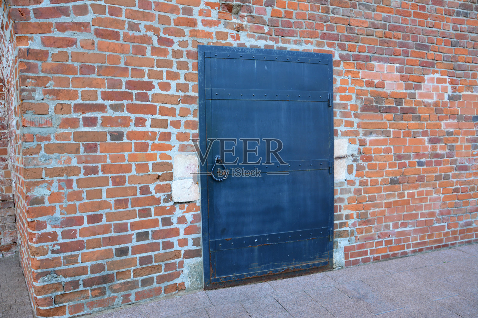 一扇钢门隔在砖墙上照片摄影图片