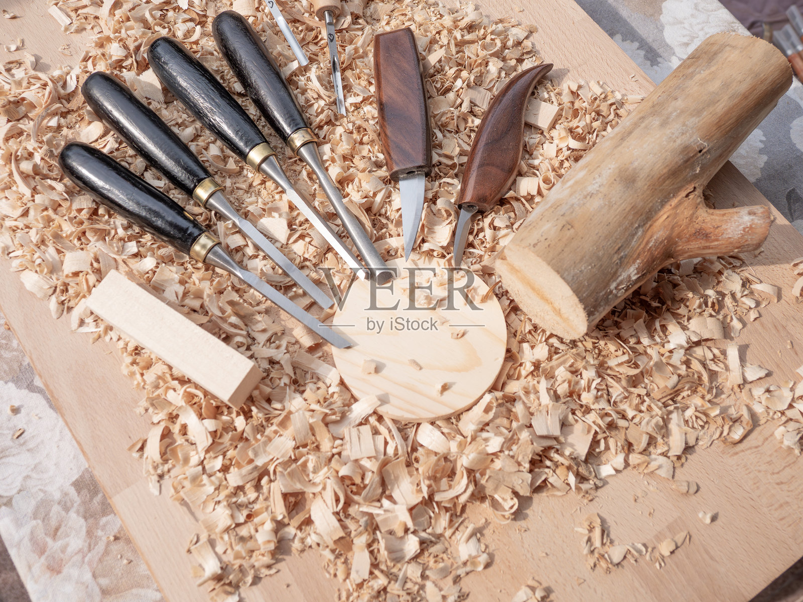 各种木雕工具散落在木片之间。照片摄影图片