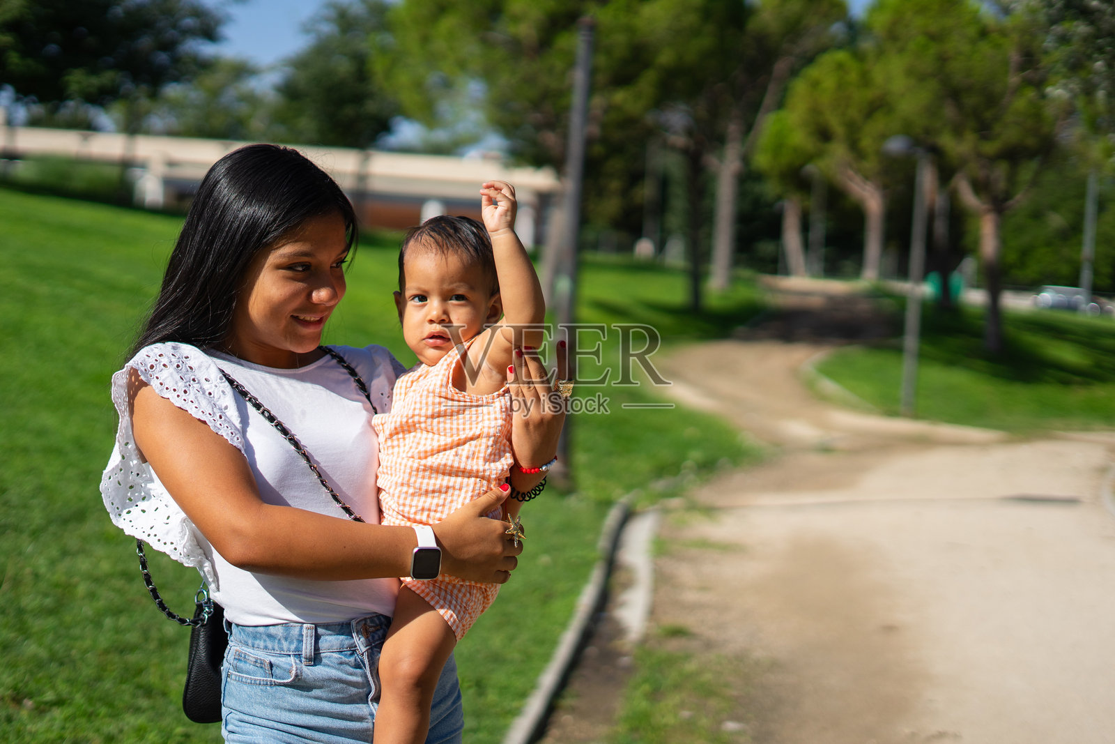 一个十几岁的女孩和她一岁的小妹妹在一个阳光明媚的日子里在公园里。带拷贝空间的拉丁族照片摄影图片