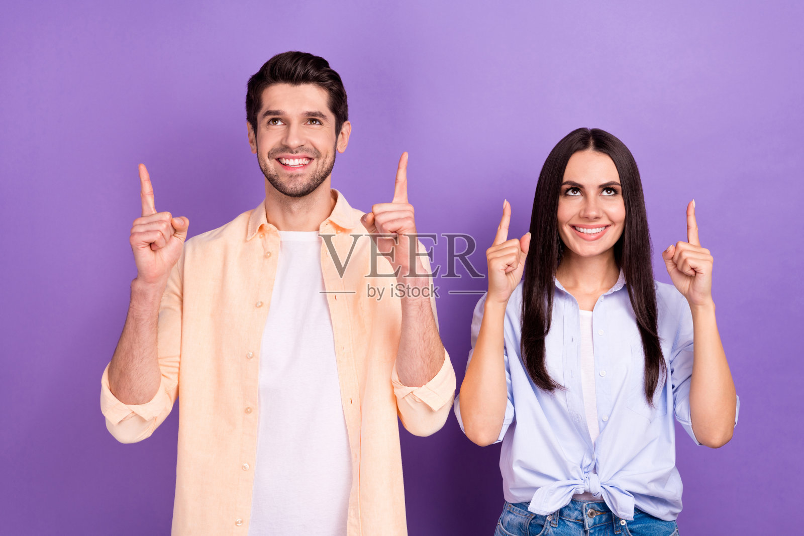 照片中欢快有趣的伙伴喜气满面，直视手指向上，空白的空间孤立在紫罗兰色的背景上照片摄影图片