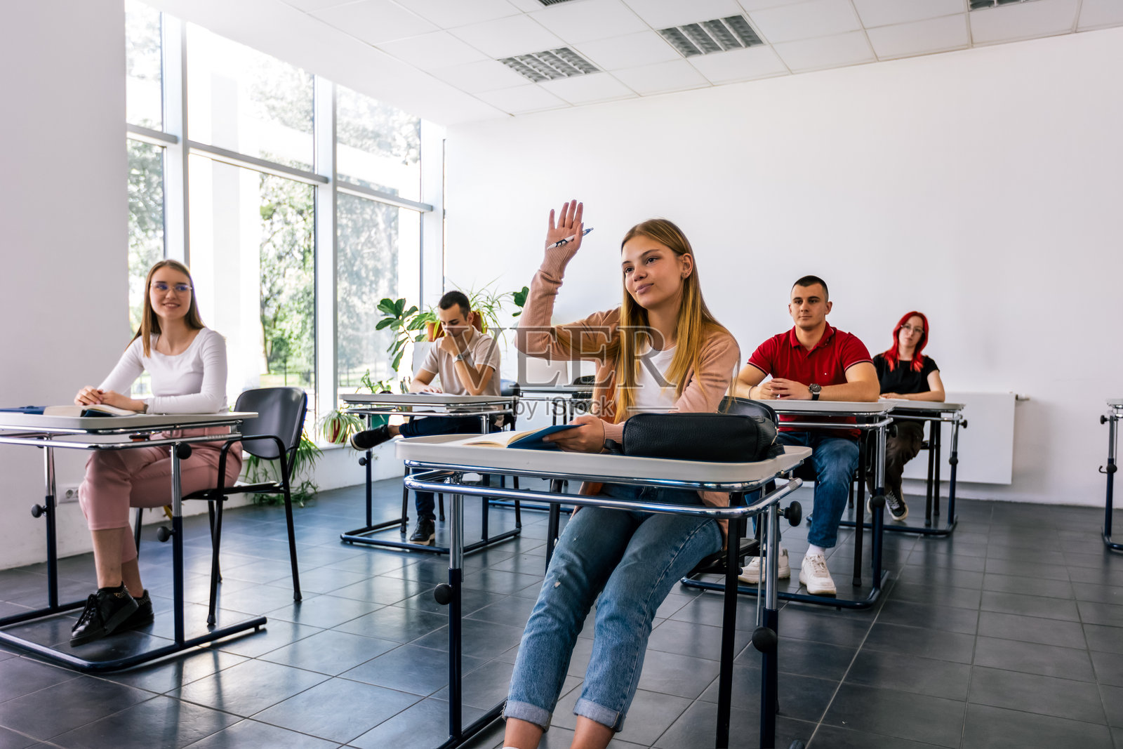 女学生在课堂上举手提问照片摄影图片
