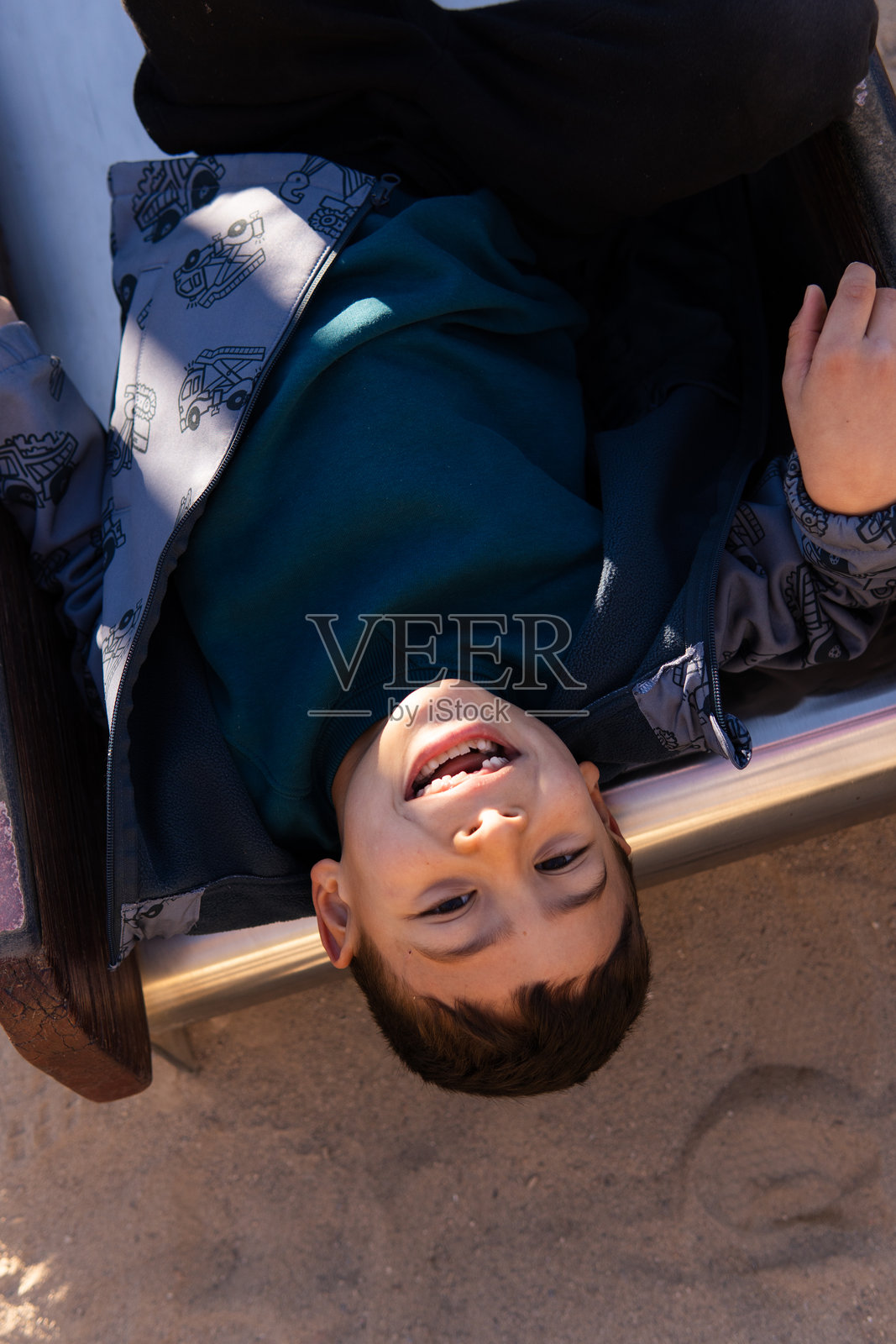 没有门牙的孩子在滑梯上开心地笑着照片摄影图片