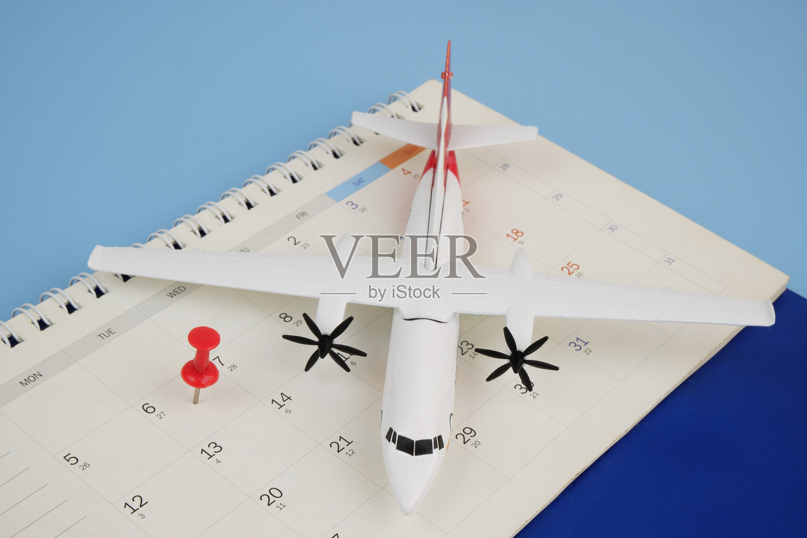 飞机模型和日历上的图钉。照片摄影图片