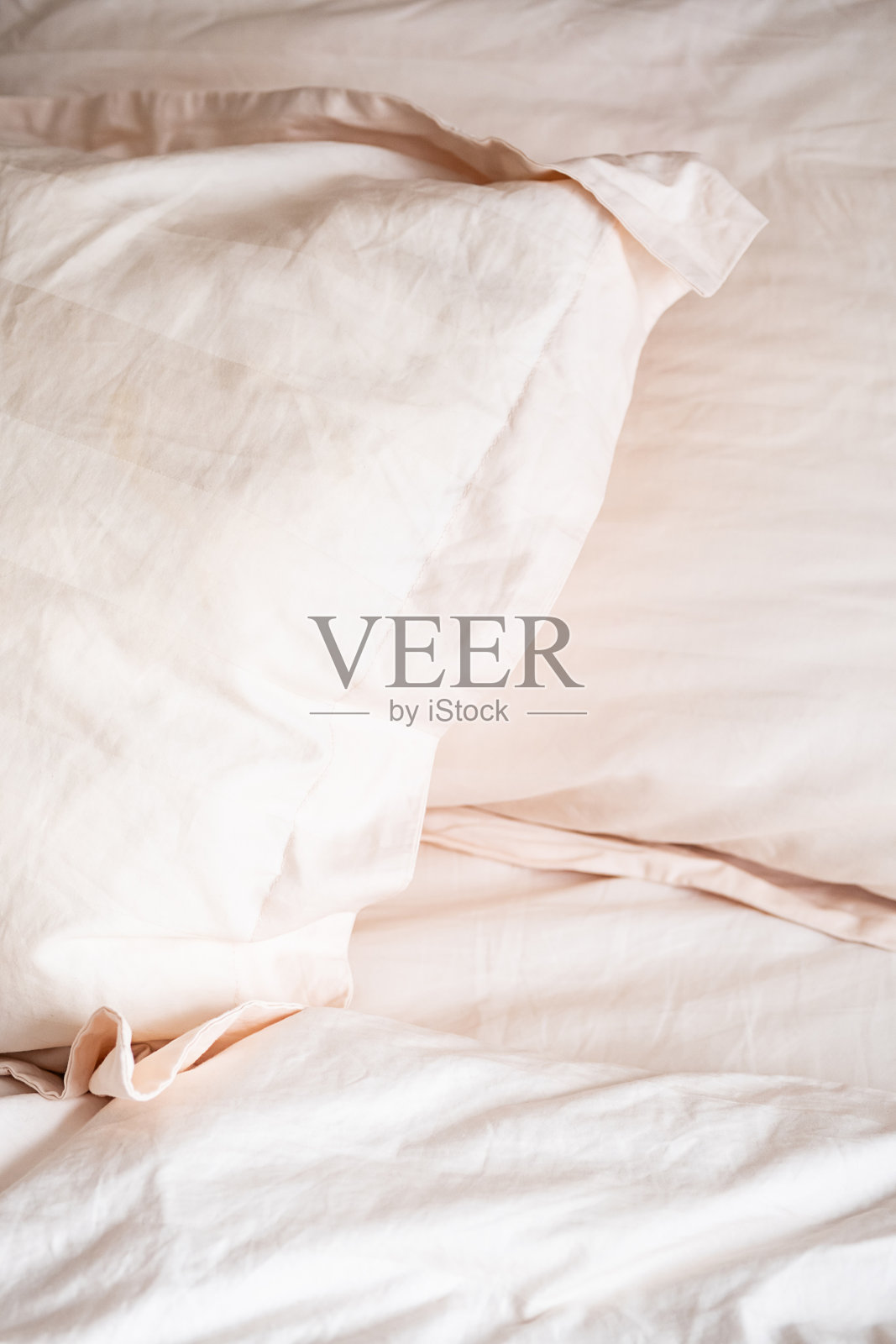 柔软的枕头和床上用品创造舒适和诱人的气氛。照片摄影图片