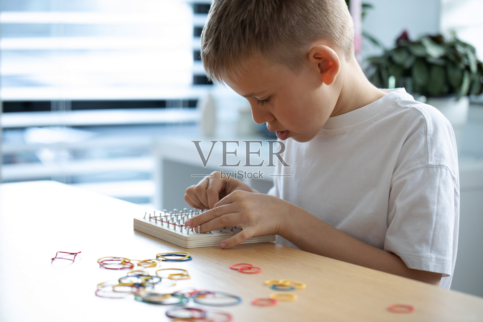 一个孩子在他的家庭环境中积极参与一个有趣的创意橡皮筋艺术活动照片摄影图片