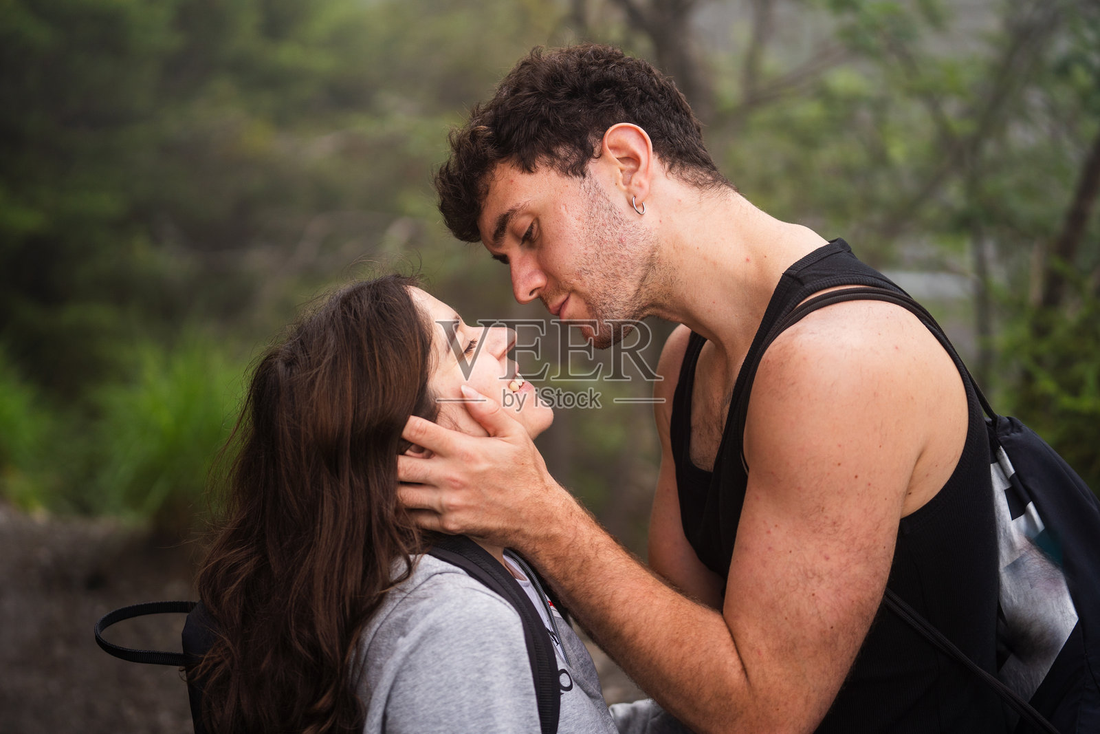 一个男人抚摸着他女朋友的脸给她一个吻照片摄影图片