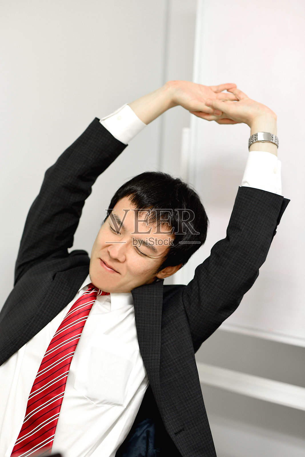 西装革履的亚洲商人在室内伸展照片摄影图片