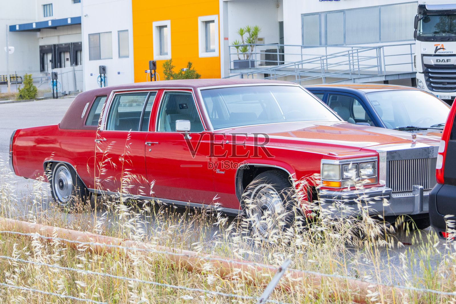 红色凯迪拉克弗利特伍德停在一座工业大楼前照片摄影图片