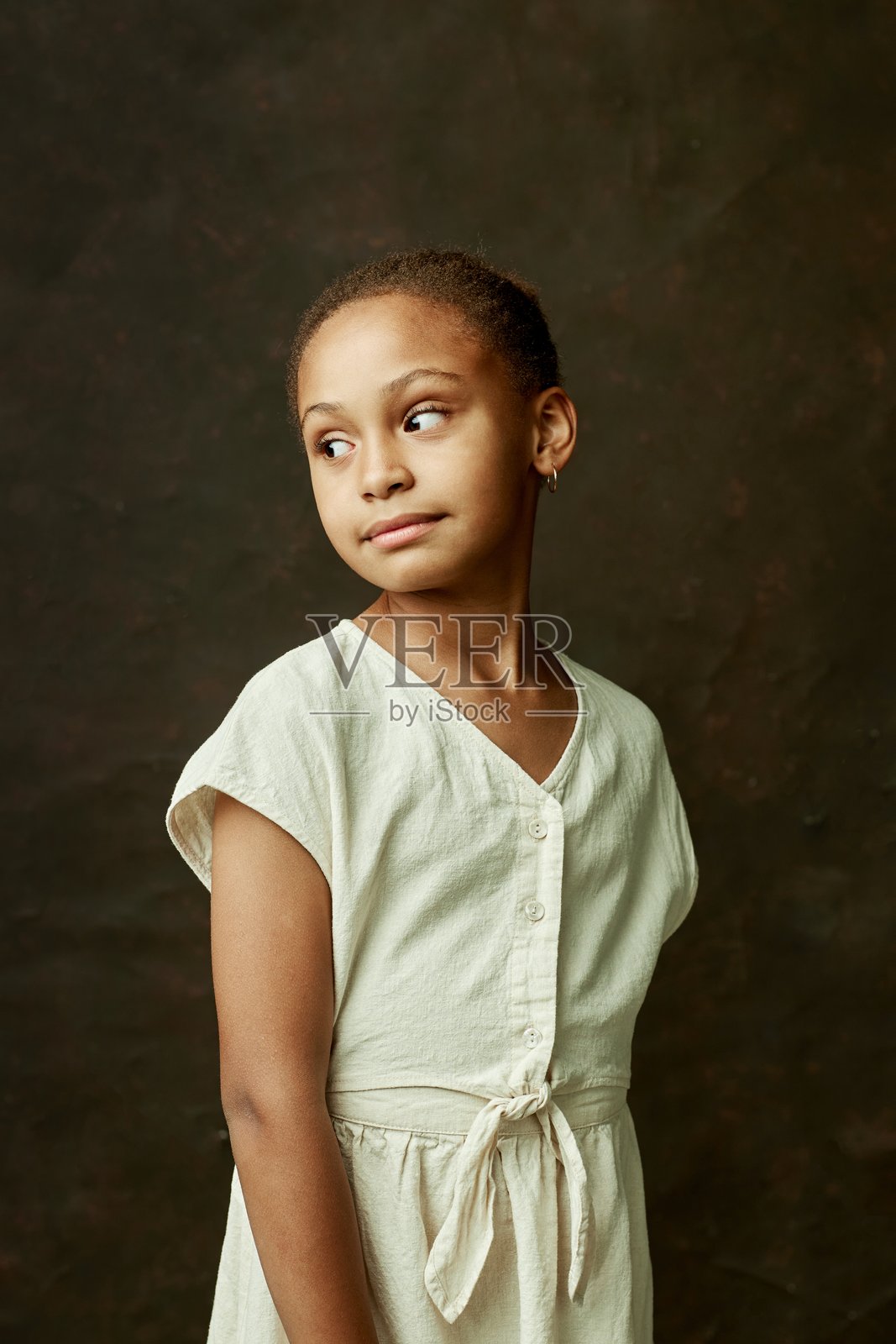工作室的黑人女孩的肖像，在白色的裙子看向远处的棕色背景照片摄影图片