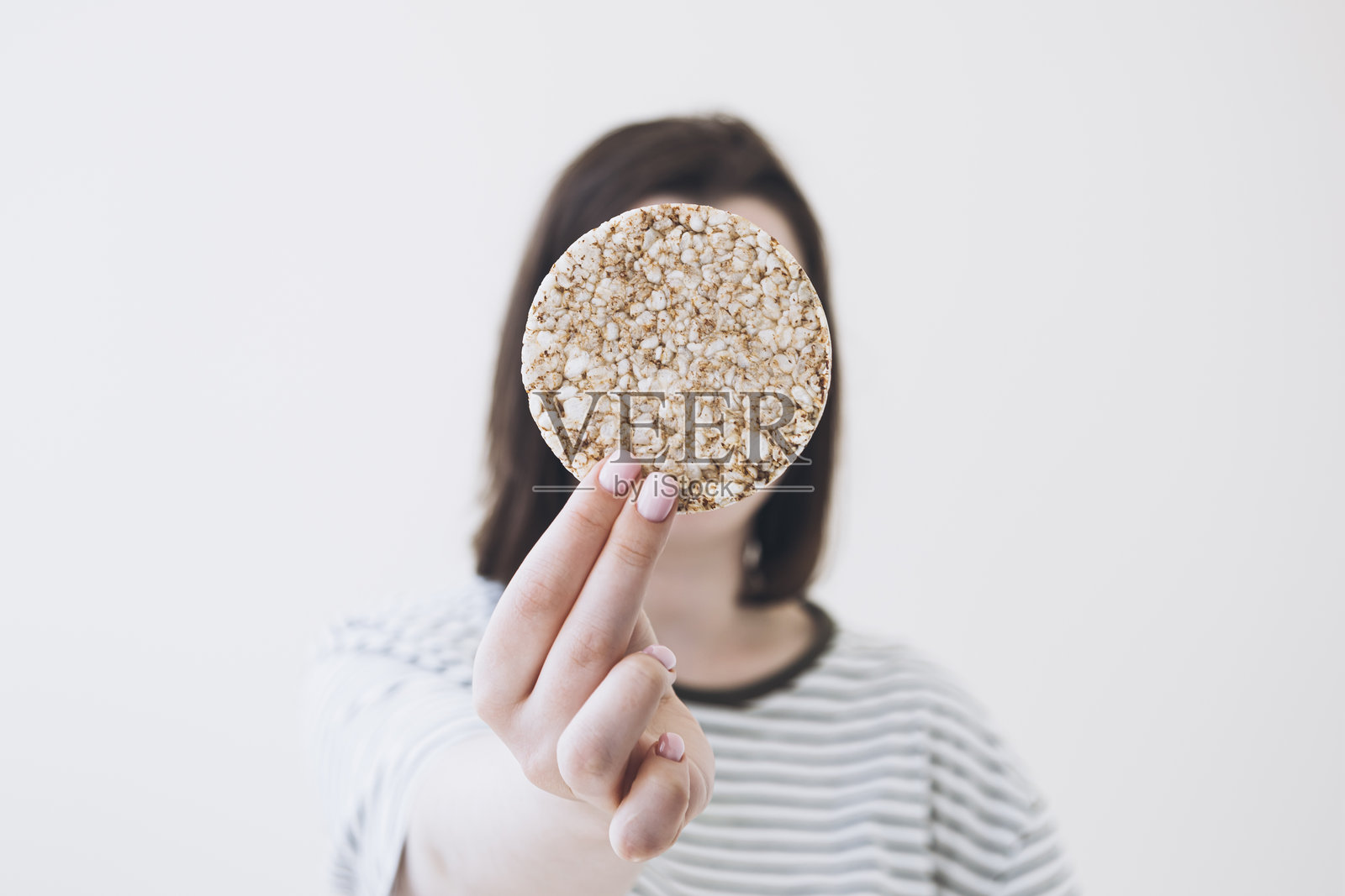 女孩手里拿着松脆的年糕。健康的食物，健康的生活方式。照片摄影图片