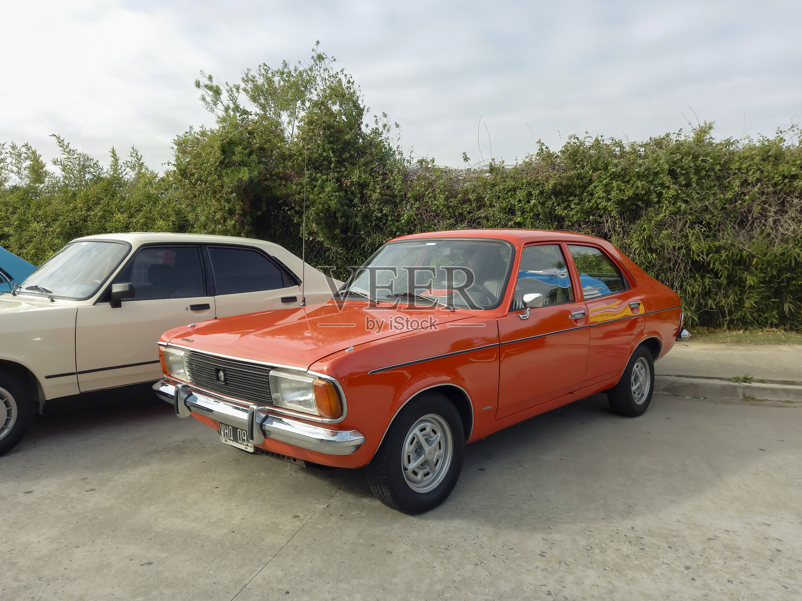 一辆70年代的旧橙色克莱斯勒道奇1500轿车停在一个经典车展的街道上照片摄影图片