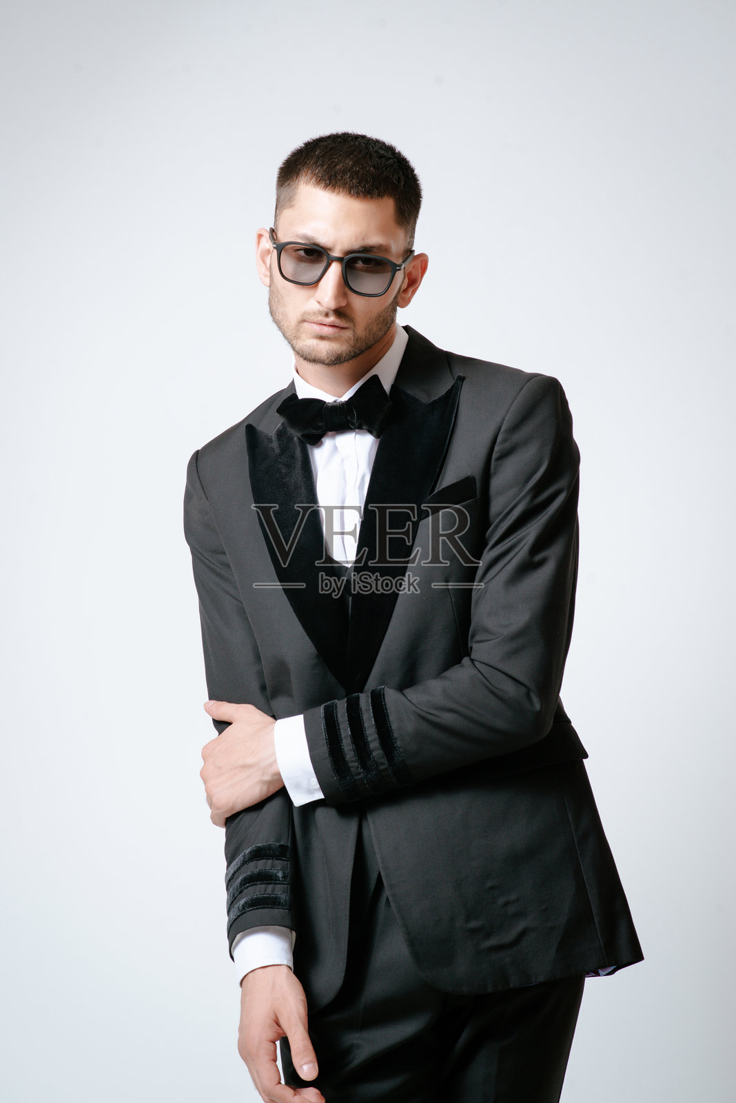帅哥，时尚模特，黑色服装，无尾礼服，领结和太阳镜照片摄影图片