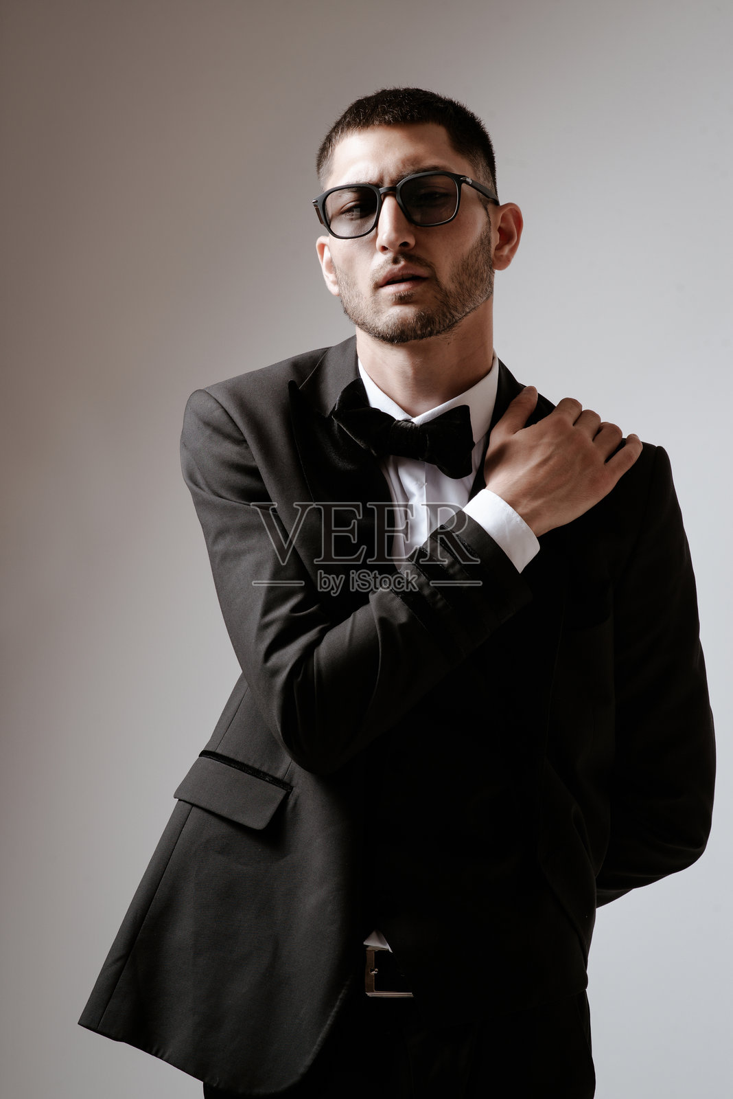 帅哥，时尚模特，黑色服装，无尾礼服，领结和太阳镜照片摄影图片
