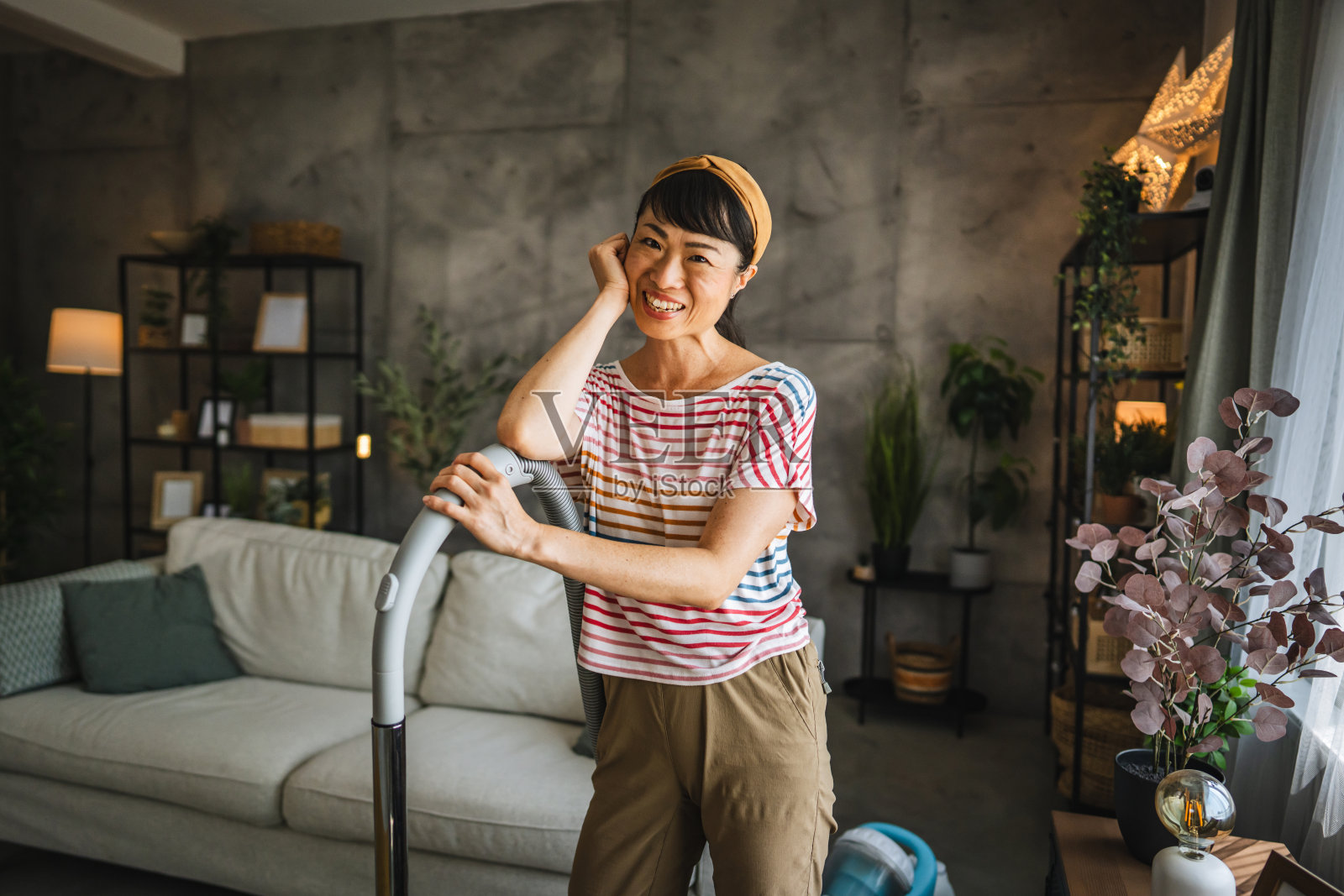 日本妇女的肖像微笑着站在真空吸尘器照片摄影图片