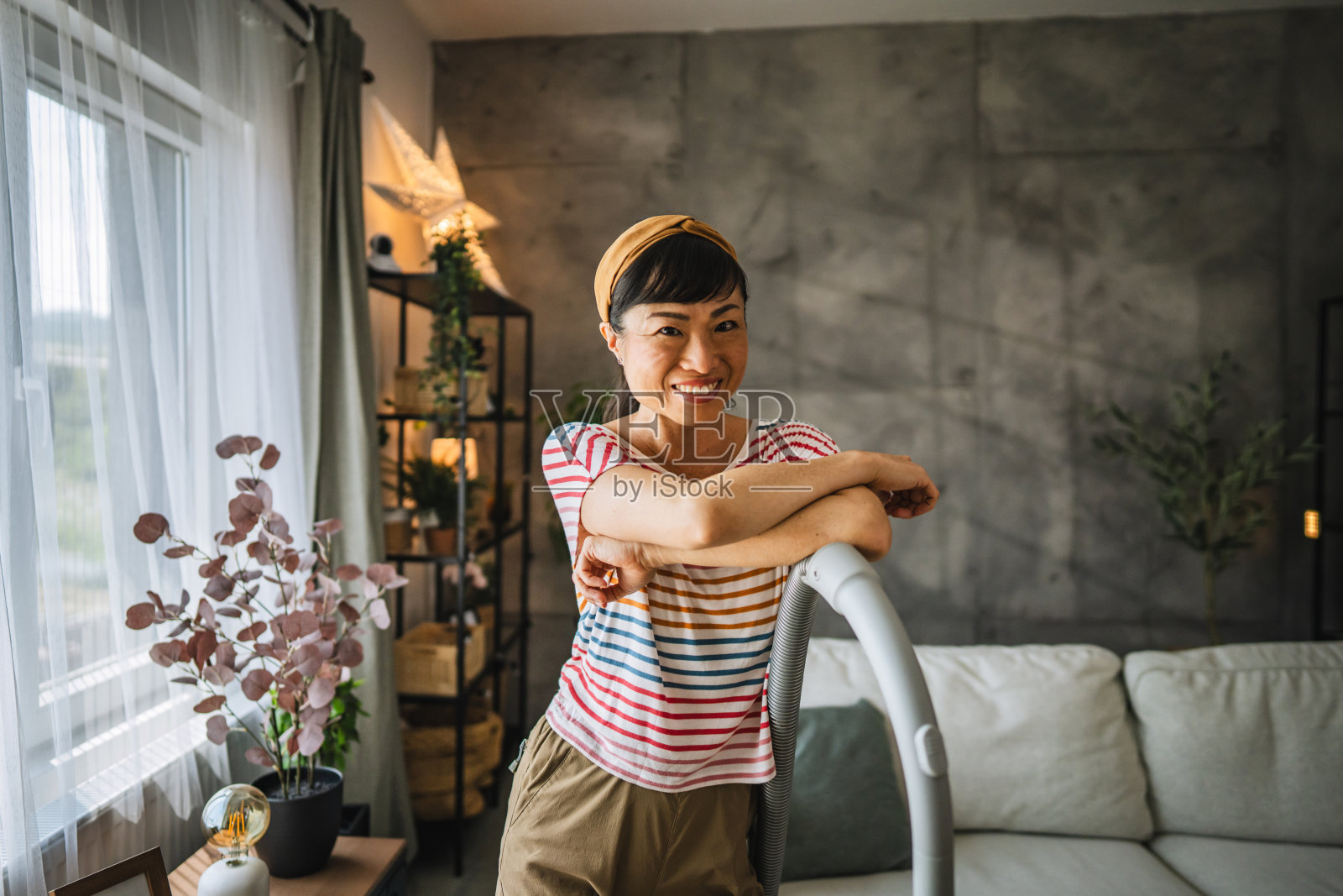 日本妇女的肖像微笑着站在真空吸尘器照片摄影图片