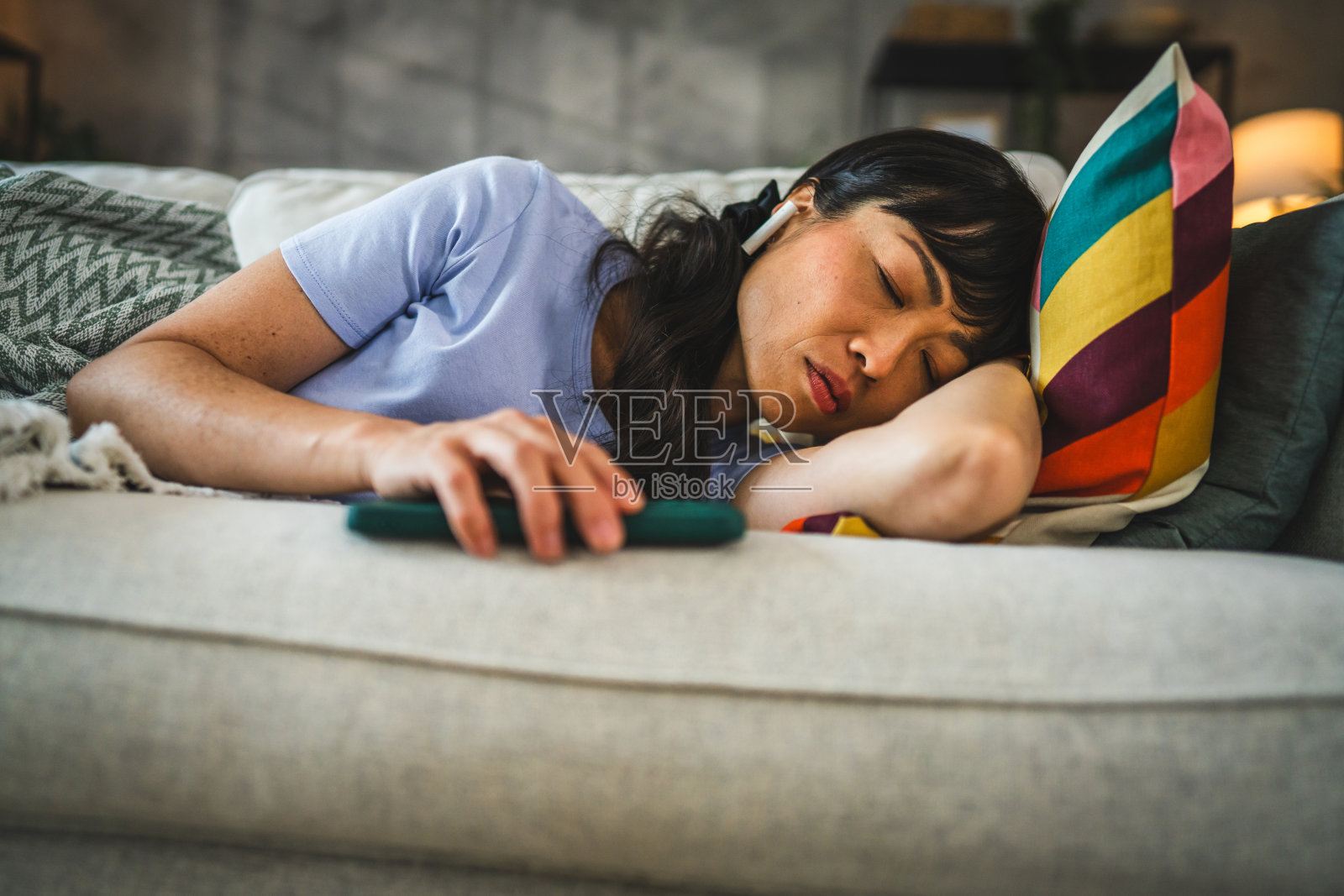 日本女子在家用完手机后倒在沙发上睡着了照片摄影图片