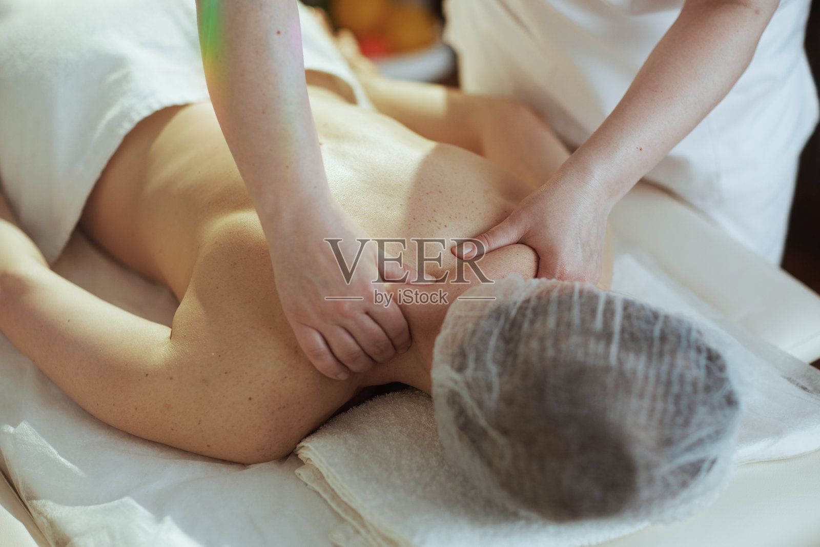 医疗按摩师在水疗沙龙按摩客户的颈部照片摄影图片