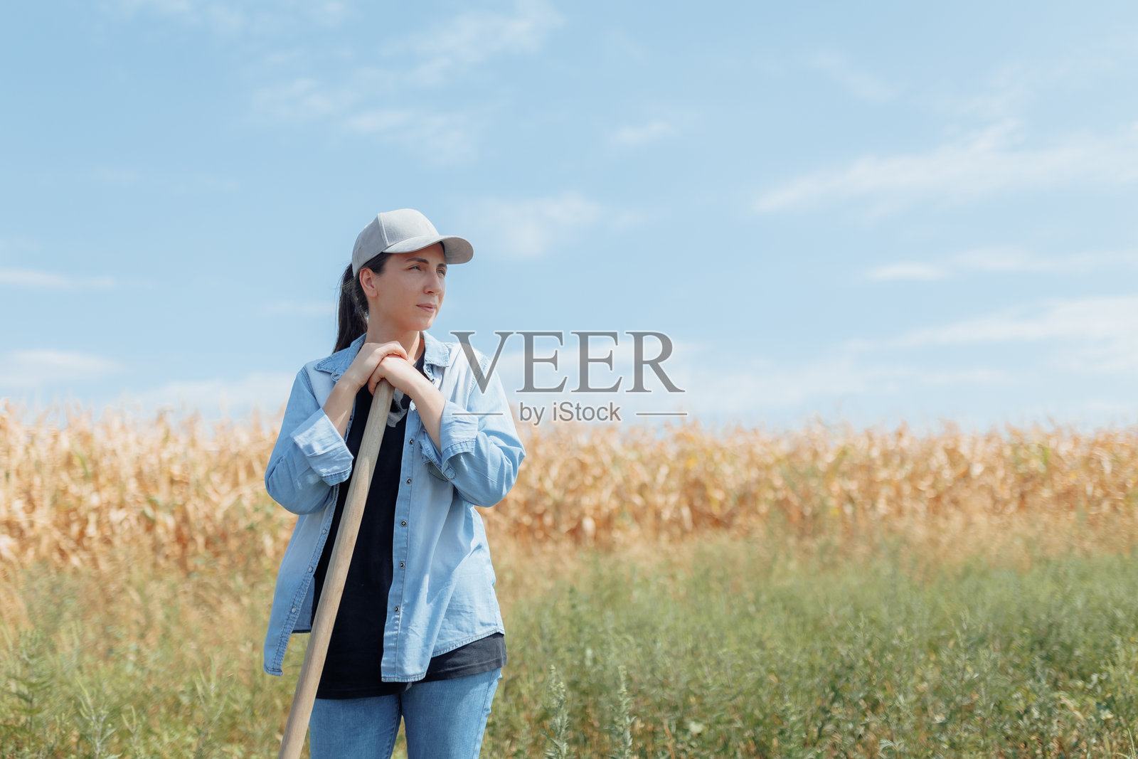 乡村生活展开，穿着便服、戴着帽子拥抱阳光的女人照片摄影图片