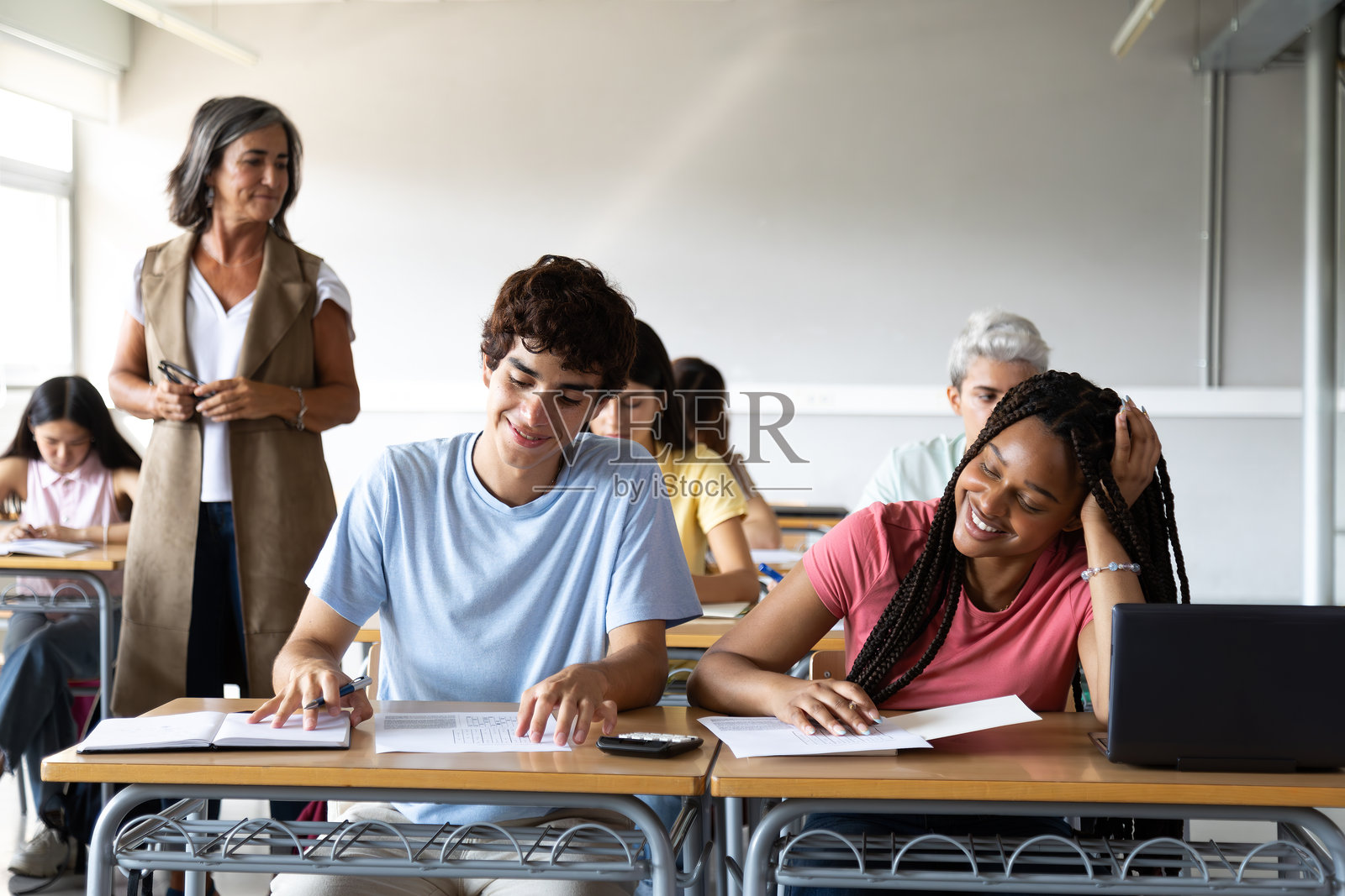快乐和微笑的青少年高中多种族学生在课堂上学习和做作业。照片摄影图片