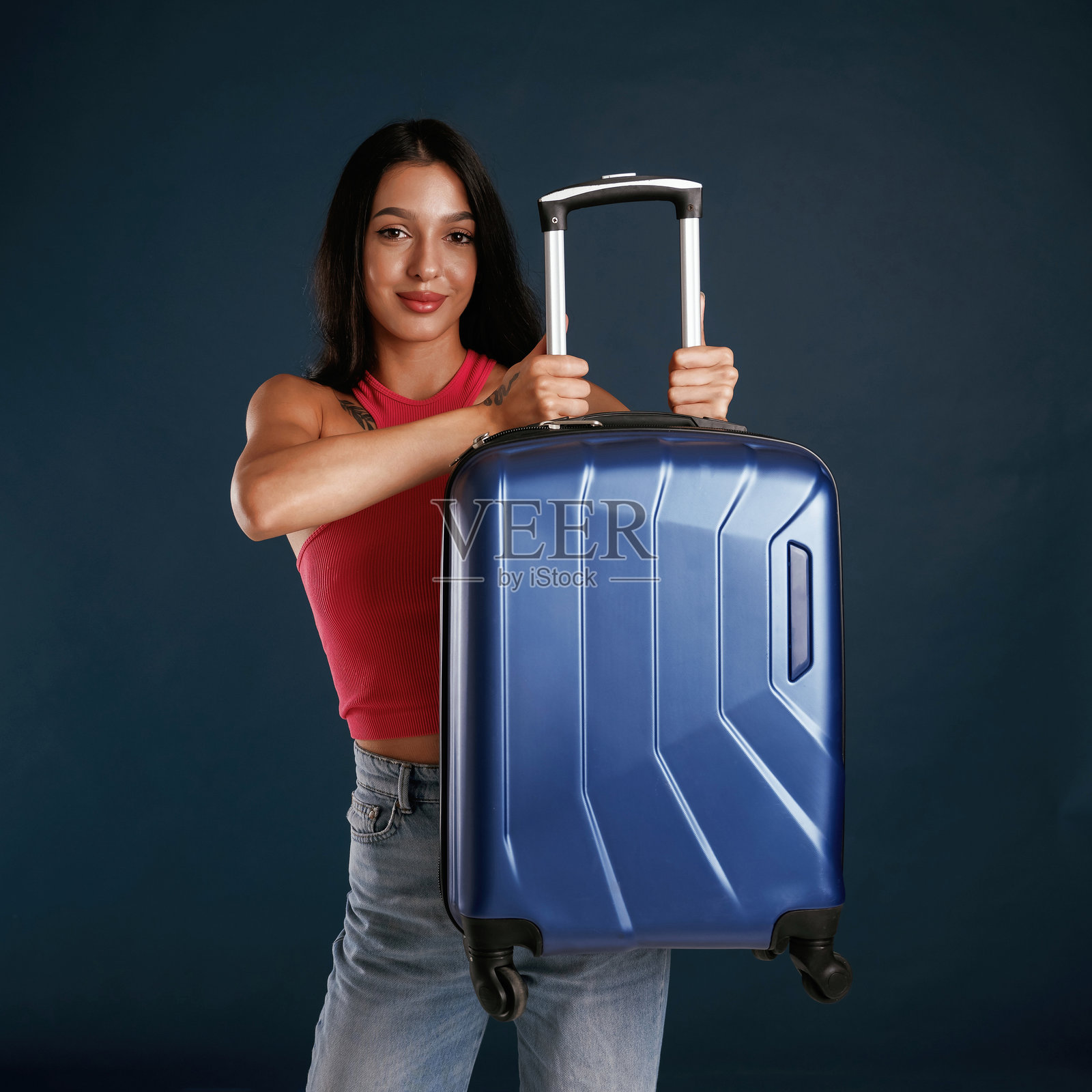 旅行构思，带着旅行箱。美丽的年轻女子在背景的衬托下照片摄影图片