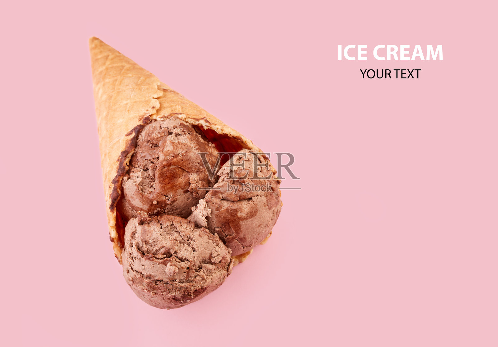 粉色背景的华夫蛋筒里装着冰淇淋球。华夫蛋筒里装着巧克力冰淇淋。照片摄影图片