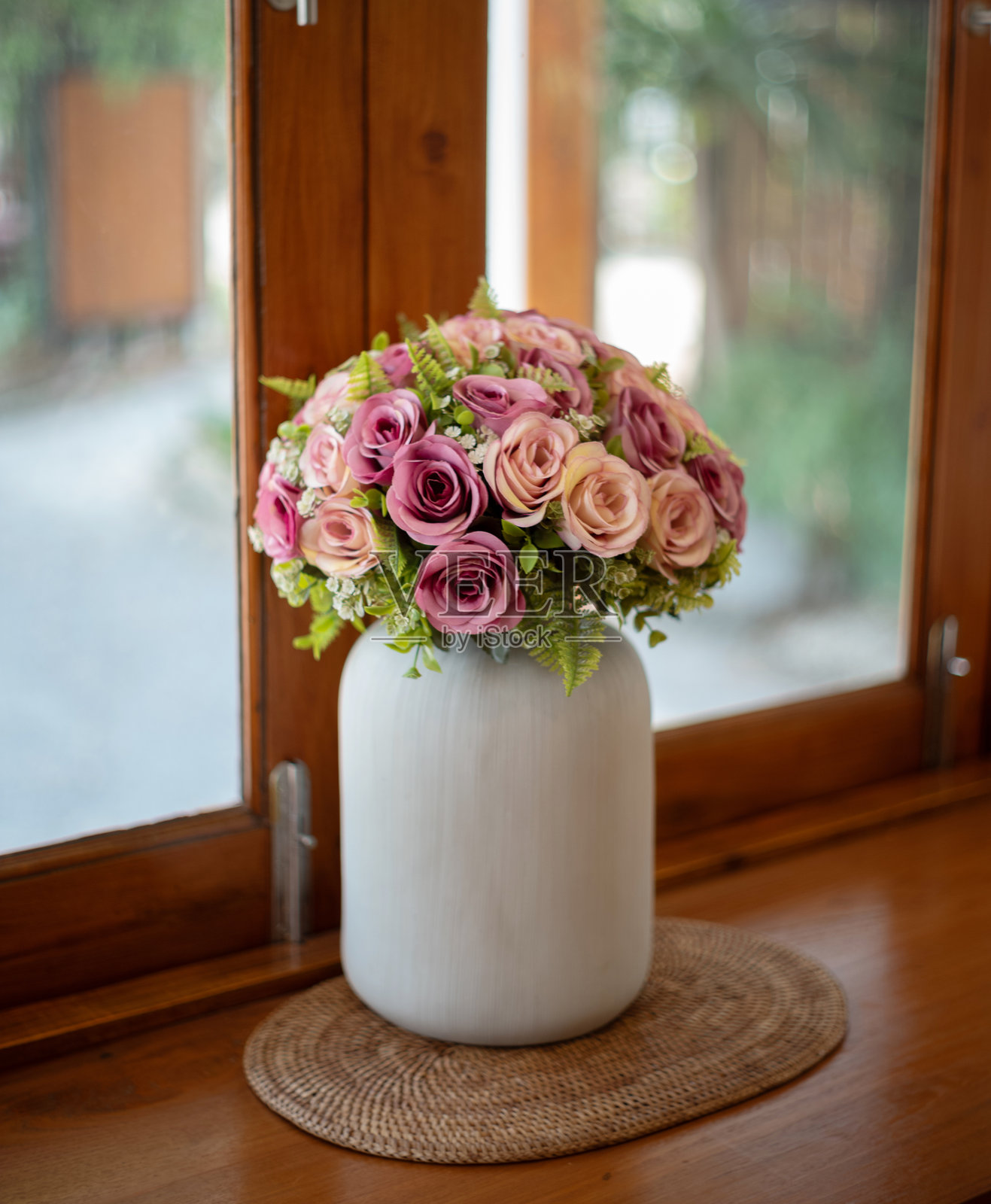 咖啡店里木桌上的假花照片摄影图片